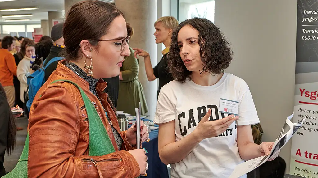 postgraduate-open-day-stand Cardiff University staff talking to prospective student